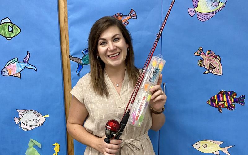 Columbia County Public Library Youth Services Librarian Kate Duong shows off the rod and reel, donated by Fish Florida, that children can receive at the June 24 adventure at Alligator Lake Park. (COURTESY)