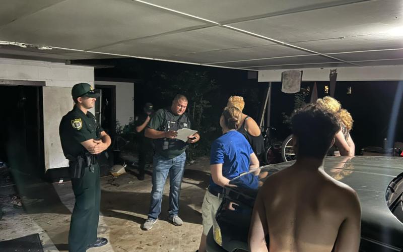 Wayne Kelly, an investigator with the Suwannee County Sheriff’s Office, talks with suspects Jacqueline White, Bridget Parks and Travis Eshleman following a drug bust Thursday night in Live Oak. (COURTESY SUWANNEE COUNTY SHERIFF’S OFFICE)