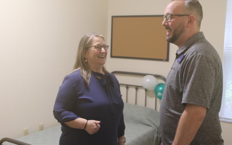 Joy Riddle, a senior vice president at Meridian, shares a laugh with Joey O’Hern, the executive director of the Lake City-Columbia County Chamber of Commerce, while showing him one of the residential rooms in the 16-bed facility. (TONY BRITT/Lake City Reporter)