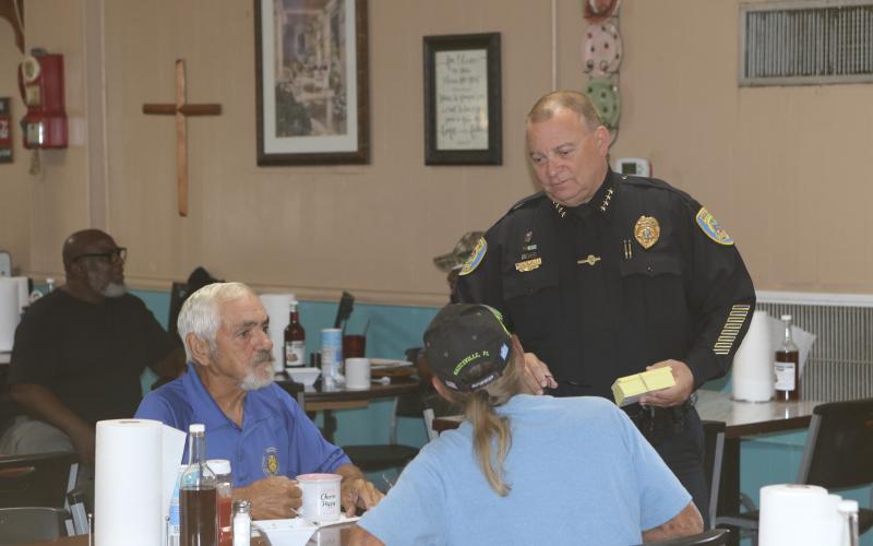 Lake City Police Department Chief Gerald Butler (right) speaks with a pair of diners at Kountry Korner on Saturday. (TONY BRITT/Lake City Reporter)