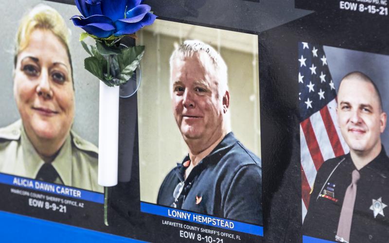 A blue rose sits next to the picture of Lt. Lonny Hempstead on the Beyond the Call of Duty’s memorial trailer that is part of the End of Watch Ride to Remember. The rose was placed there by Geraldine Adkins, Hempstead’s mother. (JACK HOWDESHELL/Special to the Reporter)
