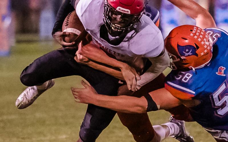 Lafayette running back Johntavious Cook is tackled by Branford’s Matt Warren last season. (BRIAN LEWIS/Special to the Reporter)