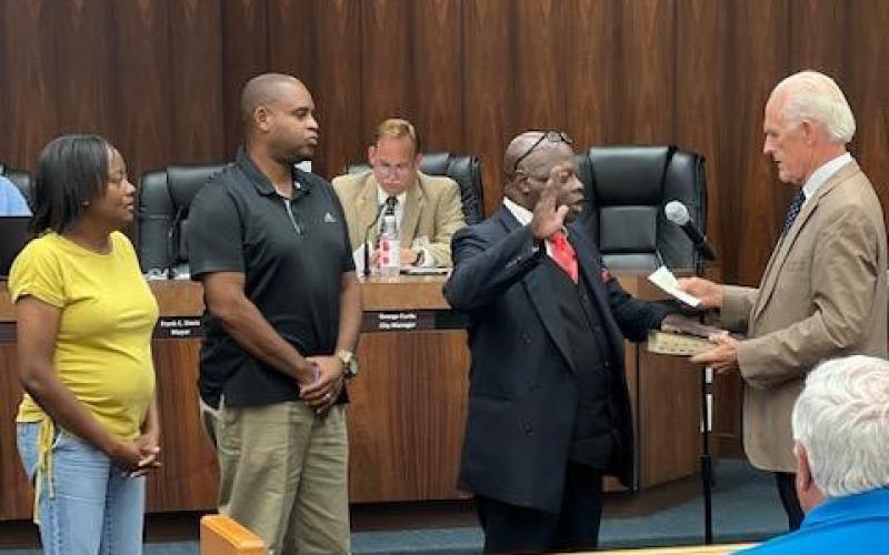 Tommie Jefferson takes the oath of office for the Live Oak City Council from Mayor Frank Davis on Tuesday as he is joined by friends for the occasion. (COURTESY)