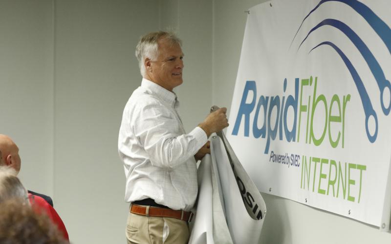 SVEC Communications Director Jon Little unveils the new logo for Rapid Fiber Internet on Tuesday. (JAMIE WACHTER/Lake City Reporter)