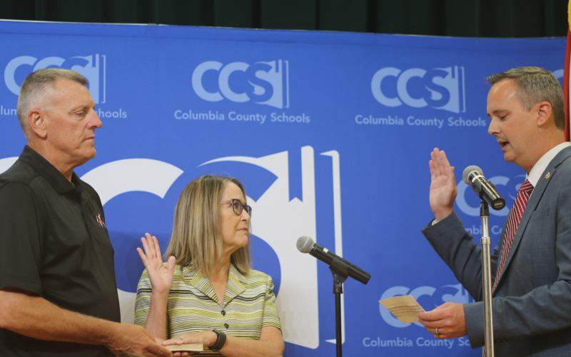 Columbia Clerk of Court Jay Swisher (right) swears in new school board member Cherie Hill ahead of Tuesday’s board meeting. (TONY BRITT/Lake City Reporter)