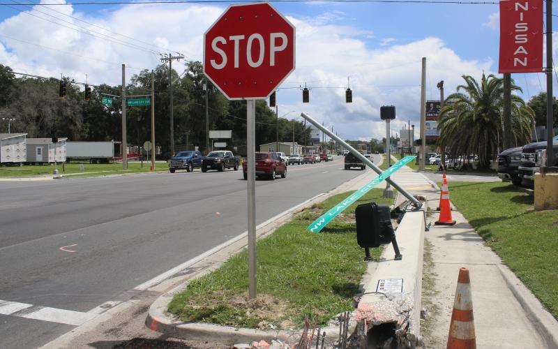 A downed crosswalk pole sits on the sidewalk near the intersection of U.S. Highway 90 and Lake City Avenue Monday afternoon after a single-vehicle crash took it down Sunday morning. (TONY BRITT/Lake City Reporter)