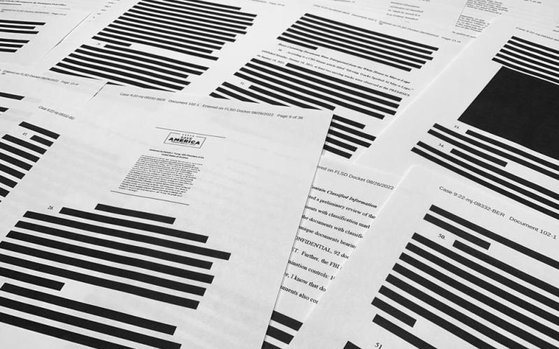 Pages from the affidavit by the FBI in support of obtaining a search warrant for former President Donald Trump's Mar-a-Lago estate are photographed Friday. U.S. Magistrate Judge Bruce Reinhart ordered the Justice Department to make public a redacted version of the affidavit it relied on when federal agents searched Trump's estate to look for classified documents. (JON ELSWICK/Associated Press)
