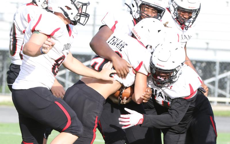Fort White linebacker Davone Calhoun (right) and defensive tackle Jaylen Brown (above) make a tackle during a team scrimmage on Aug. 12. (MORGAN MCMULLEN/Lake City Reporter)