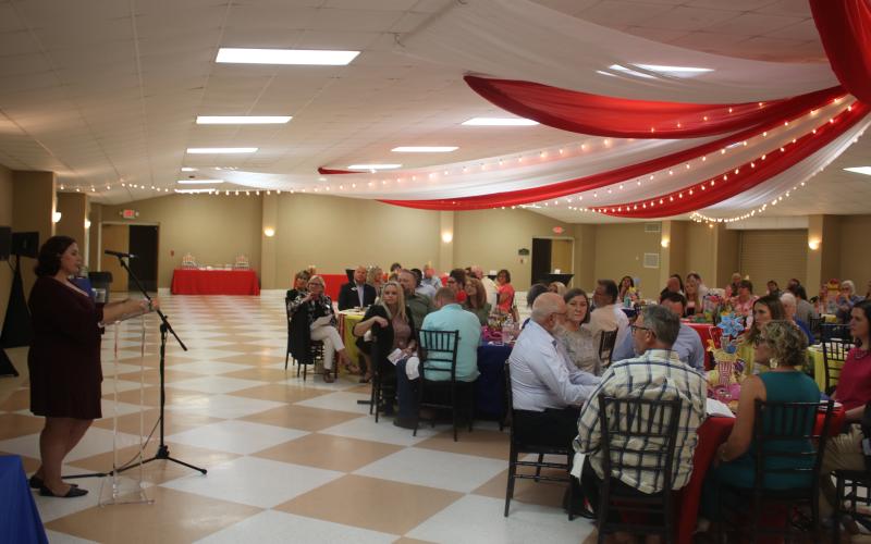 Jamie Lane (standing), a United Way of Suwannee Valley case worker, addresses the audience during the organization’s campaign kickoff Thursday night at the Florida Gateway Fairgrounds exhibition hall. (TONY BRITT/Lake City Reporter)