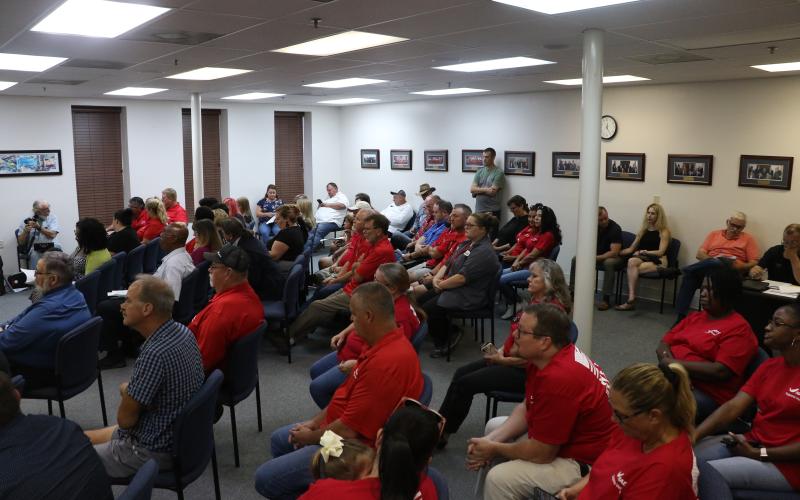 HAECO Americas employees and supporters wore matching red shirts to Thursday’s city council meeting. The city and HAECO are currently negotiating a renewal of HAECO’s lease at Lake City Gateway Airport. (MORGAN MCMULLEN/Lake City Reporter)