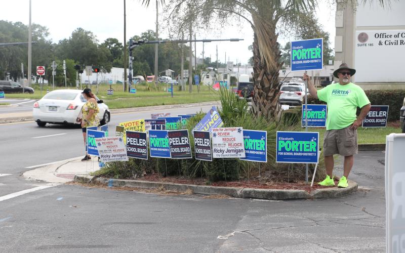 Volunteers for candidates stand outside the Columbia County Supervisor of Elections office in Lake City during the first week of early voting. (MORGAN MCMULLEN/Lake City Reporter)