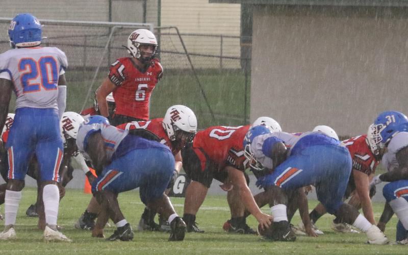 Fort White quarterback Clayton Philpot gets set for the snap in a driving rainstorm during Friday’s game against Taylor County. (MORGAN MCMULLEN/Lake City Reporter)