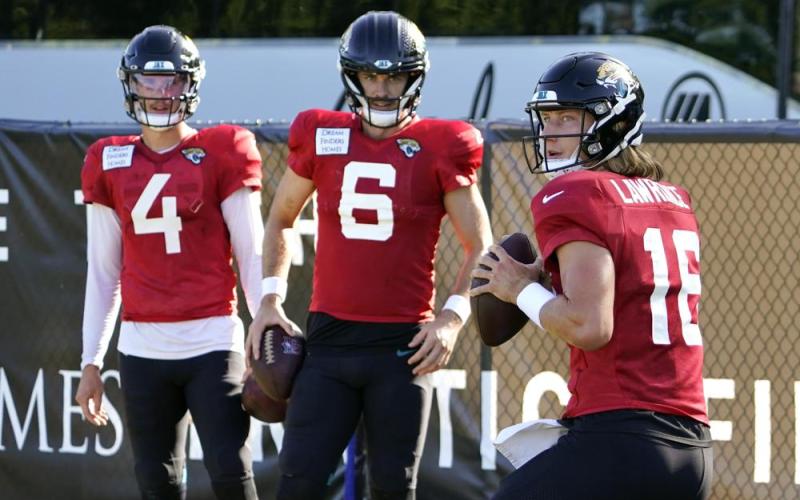 Jacksonville Jaguars quarterback Trevor Lawrence (16) runs through a drill as quarterbacks Kyle Sloter (4) and Jake Luton (6) look on during practice on Sunday in Jacksonville. (JOHN RAOUX/Associated Press)