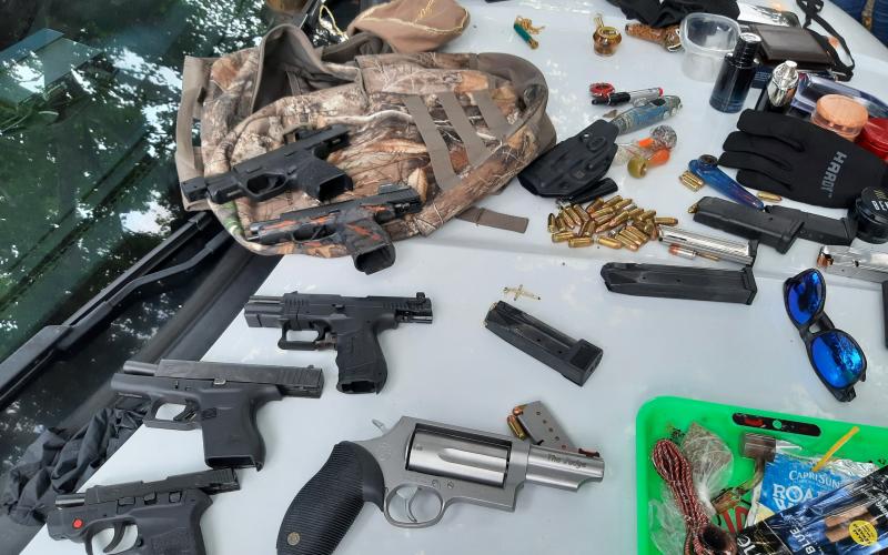 Firearms and drug paraphernalia are laid out after being confiscated from a trio of teens Tuesday. (COURTESY CCSO)