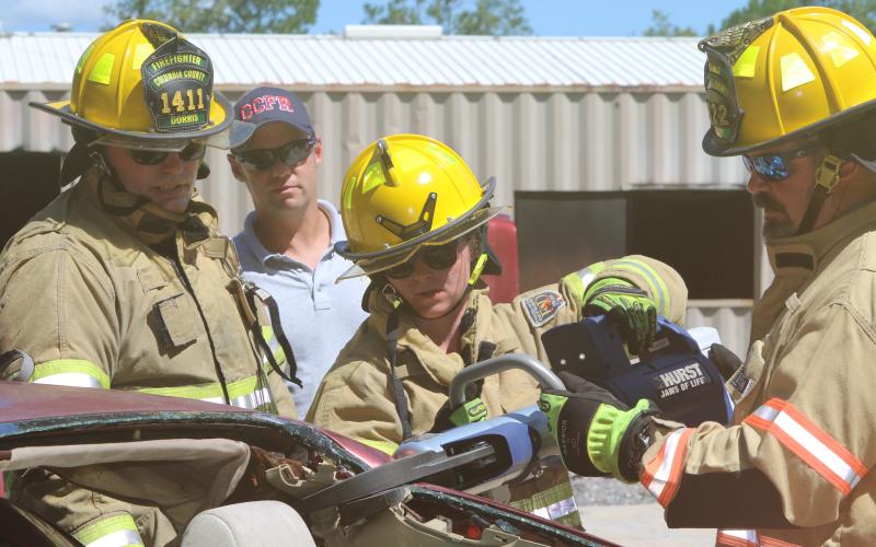 Columbia County firefighters Jessica Islam (center) and Bryan King (right) work with the Hurst Jaws of Life as Tyler Dorris (left) looks on Tuesday. (TONY BRITT/Lake City Reporter)