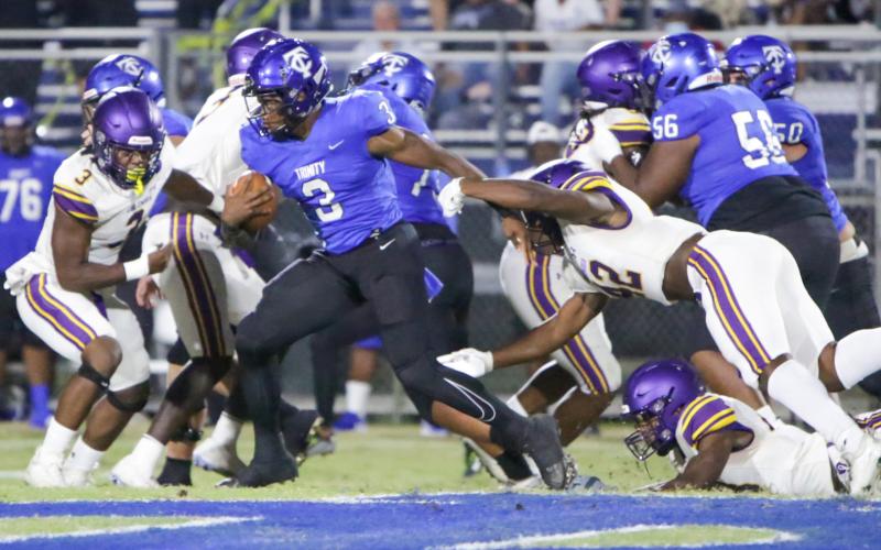 Trinity Christian running back Treyaun Webb runs past Columbia linebacker Au’vontae Smith during Friday night’s game. (BRENT KUYKENDALL/Lake City Reporter)