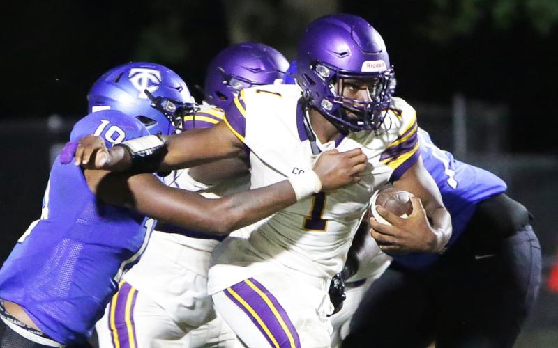 Columbia quarterback Tyler Jefferson fights through a tackle from Trinity Christian linebacker Tomarion McCray on Friday. (BRENT KUYKENDALL/Lake City Reporter)
