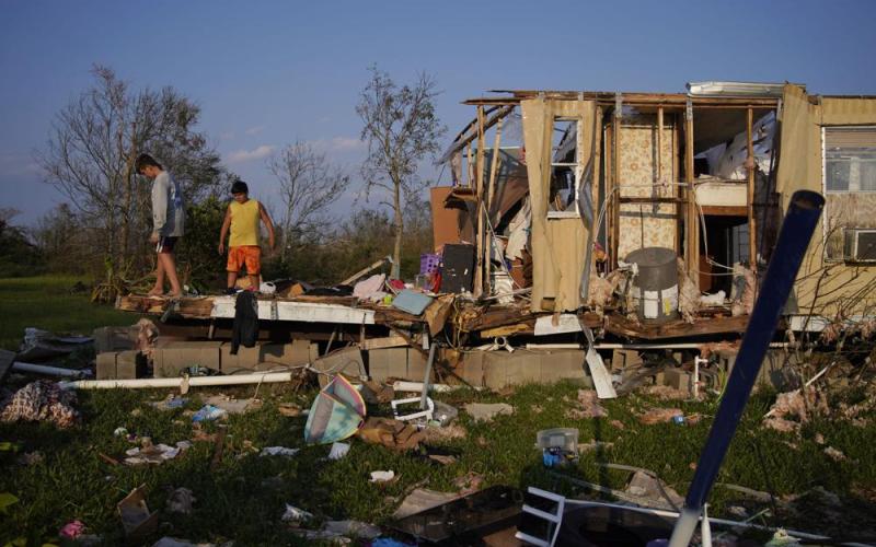 Aiden Locobon, left, and Rogelio Paredes look through the remnants of their family’s home destroyed by Hurricane Ida, Sept. 4, 2021, in Dulac, La. (JOHN LOCHER/AP File)