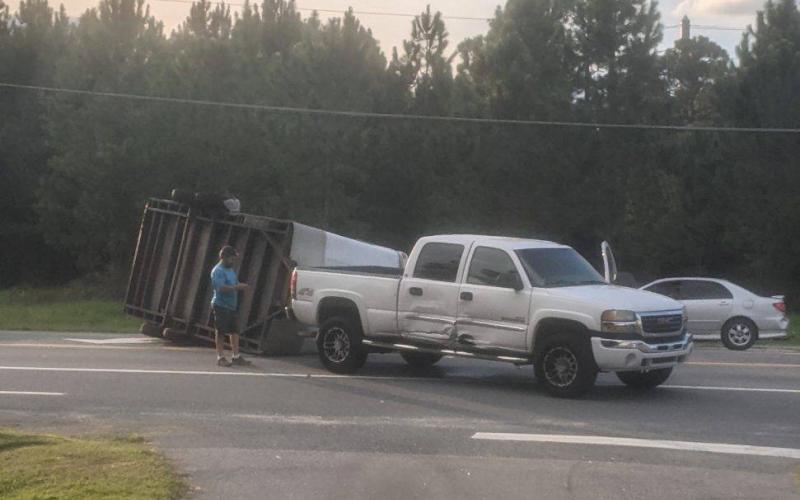 A trailer lies overturned on Branford Highway (State Road 247) on Tuesday evening after a crash following an improper U-Turn. (COURTESY GLENN ALLEN)
