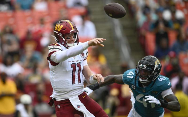 Washington Commanders quarterback Carson Wentz throws a pass as Jacksonville Jaguars linebacker Josh Allen chases after him during Sunday’s game in Landover, Md. (NICK WASS/Associated Press)