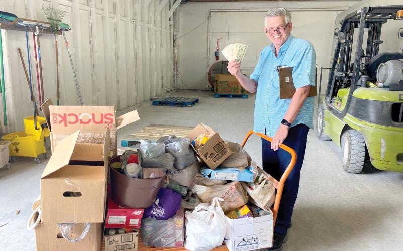 Florida Gateway Food Bank Manager David Boozer smiles with a load of food and cash donations raised during the Suwannee Valley Food Fight to End Hunger. (COURTESY)