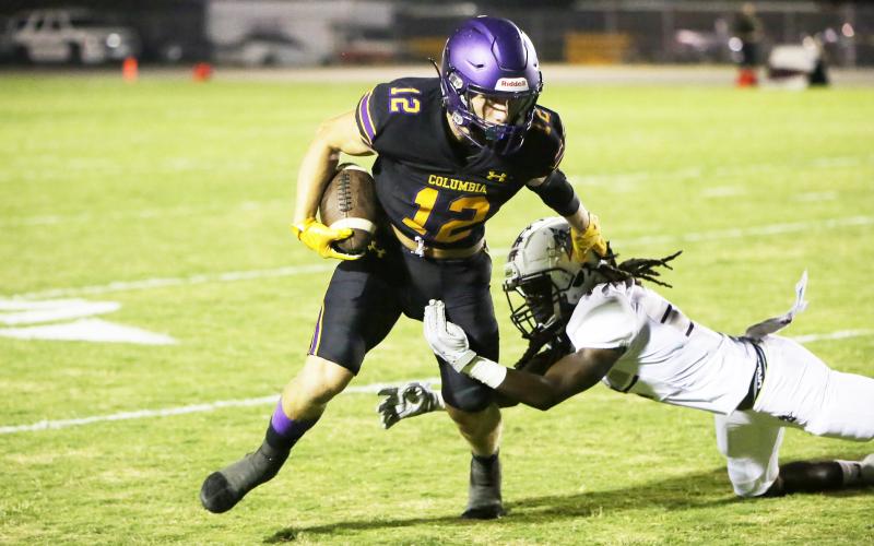 Columbia receiver Camdon Frier tries to evade a tackle by a Madison County defender on Friday. (BRENT KUYKENDALL/Lake City Reporter)