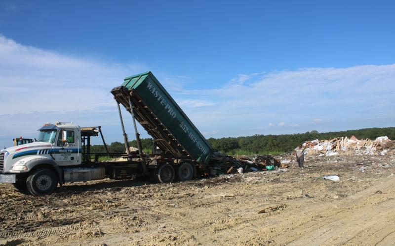 A pair of Waste Pro employees oversee the dumping of a truckload of garbage at the Columbia County Landfill. (TONY BRITT/Lake City Reporter)
