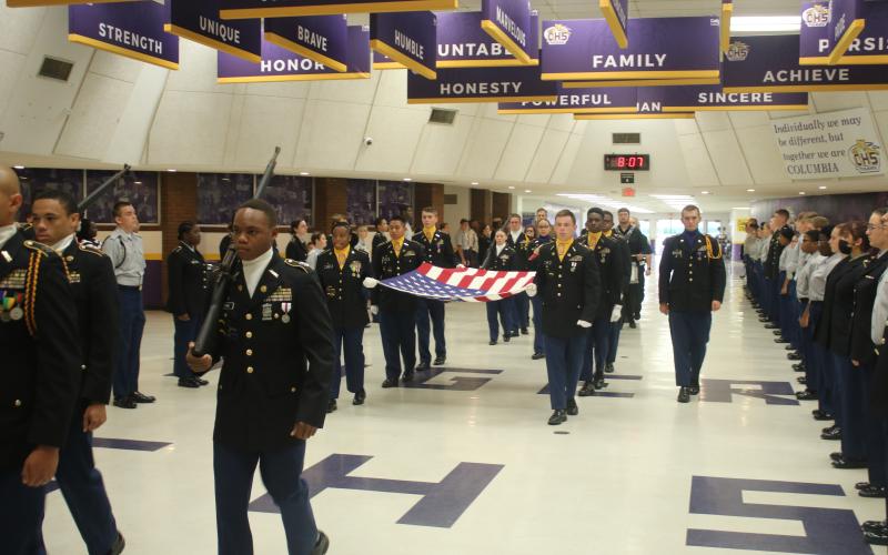 Cadets with the Columbia High School JROTC march the American flag through the school’s commons area Monday morning in a ceremony honoring the victims of the Sept. 11, 2001, terrorist attacks. (TONY BRITT/Lake City Reporter)