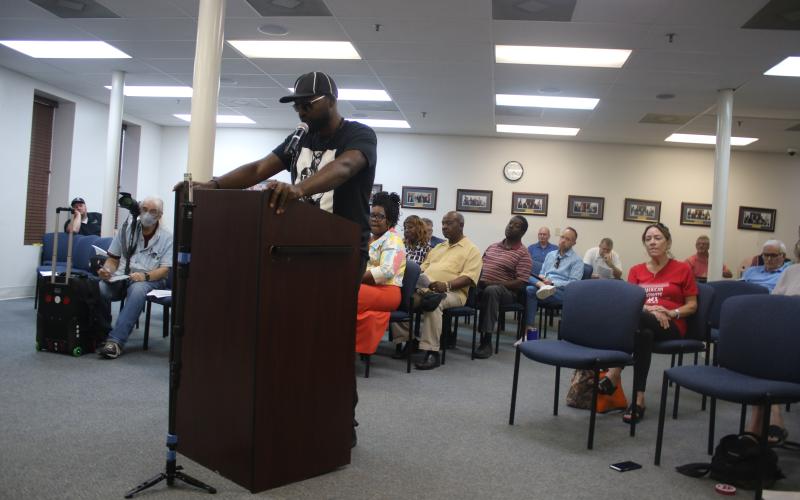 Community activist Sylvester Warren reads off the reason for a ‘penalty flag’ being thrown against Councilman Todd Sampson during the Lake City Council meeting Monday evening. (TONY BRITT/Lake City Reporter)