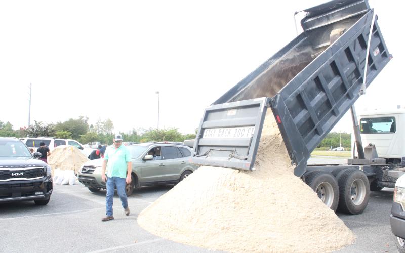An additional load of sand is dumped at the Southside Sports Complex on Tuesday morning as residents bagged sandbags in preparation for Hurricane Ian. (TONY BRITT/Lake City Reporter)