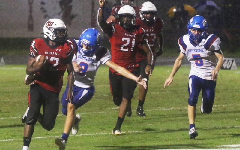 Fort White receiver Najeeb Smith rushes up the field ahead of Keystone Heights’ Wyatt Van zant on Friday. (MORGAN MCMULLEN/Lake City Reporter)