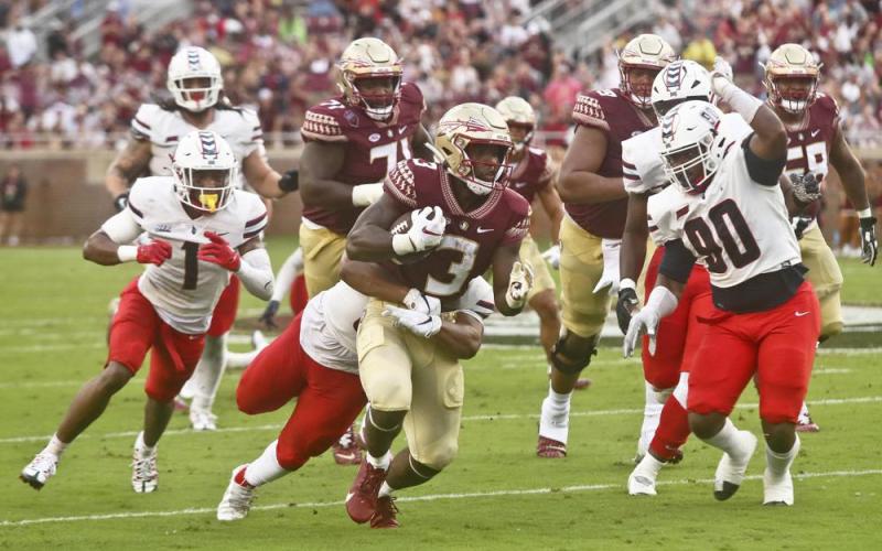 Florida State running back Trey Benson (3) fights for extra yardage as Duquesne defenders pursue in the Seminoles' Week 1 game in Tallahassee. (PHIL SEARS/Associated Press)