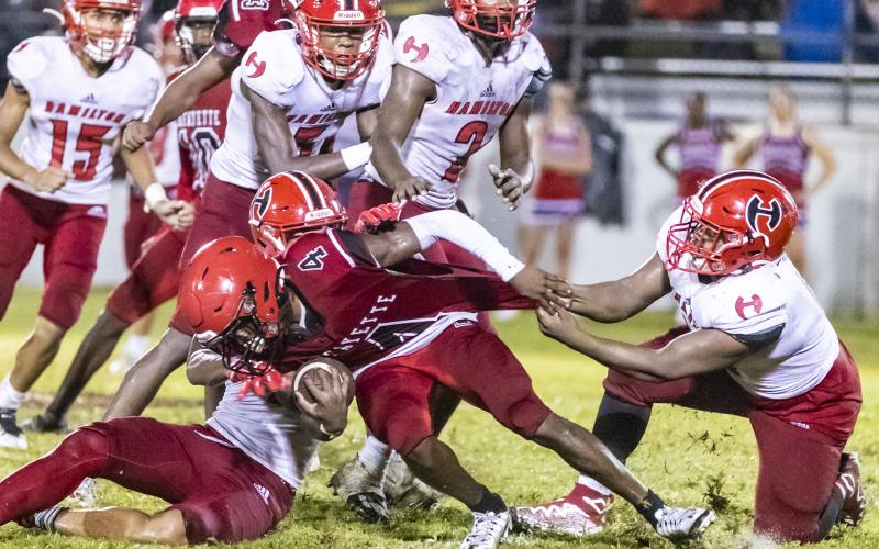 Lafayette running back Kiami McKnight is tackled by a host of Hamilton County defenders on Sept. 16. (JACK HOWDESHELL/Special to the Reporter)