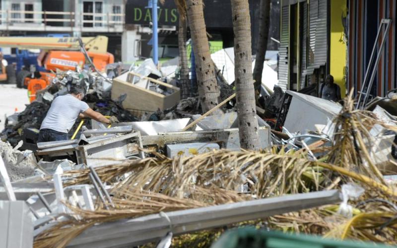 A man hauls debris away from a pizza restaurant that was badly damaged by Hurricane Ian at Fort Myers Beach on Sunday. (JAY REEVES/Associated Press)