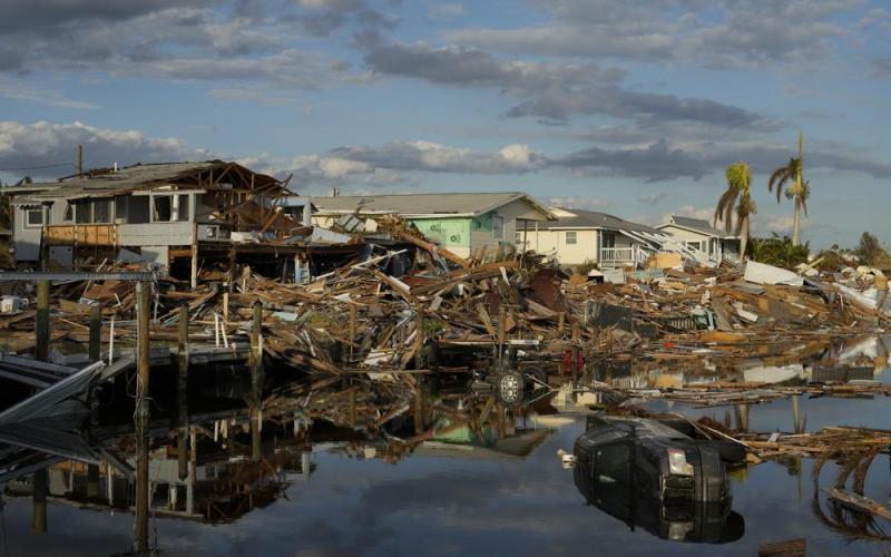Cars and debris from washed away homes line a canal in Fort Myers Beach on Wednesday, one week after the passage of Hurricane Ian. Hurricane Ian confounded one key computer forecast model, creating challenges for forecasters and Florida residents. (REBECCA BLACKWELL/Associated Press)