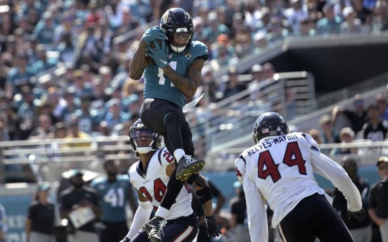 Jacksonville Jaguars wide receiver Marvin Jones Jr. catches the ball between Houston Texans cornerback Derek Stingley Jr. (24) and linebacker Jalen Reeves-Maybin (44) last Sunday in Jacksonville. (PHELAN M. EBENHACK/Associated Press)