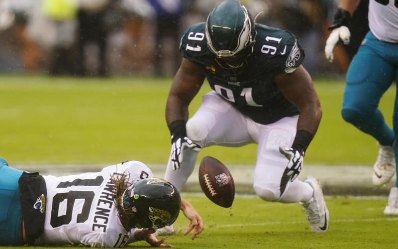 Jacksonville Jaguars quarterback Trevor Lawrence fumbles the ball and Philadelphia Eagles defensive lineman Fletcher Cox recovers it during Sunday’s game in Philadelphia. (CHRIS SZAGOLA/Associated Press)