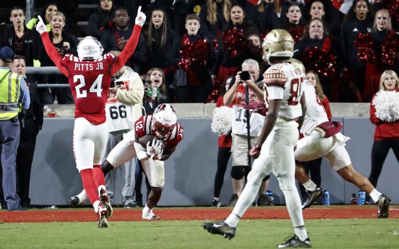 N.C. State defensive back Devan Boykin (12) intercepts a pass intended for Florida State's Mycah Pittman as N.C. State cornerback Derrek Pitts Jr. (24) celebrates during Saturday's game in Raleigh, N.C. (KARL B DEBLAKER/Associated Press)