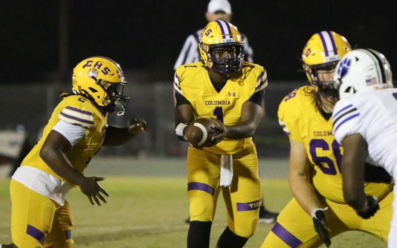 Columbia quarterback Tyler Jefferson hands the ball off against Ridgeview on Friday night. (BRENT KUYKENDALL/Lake City Reporter)