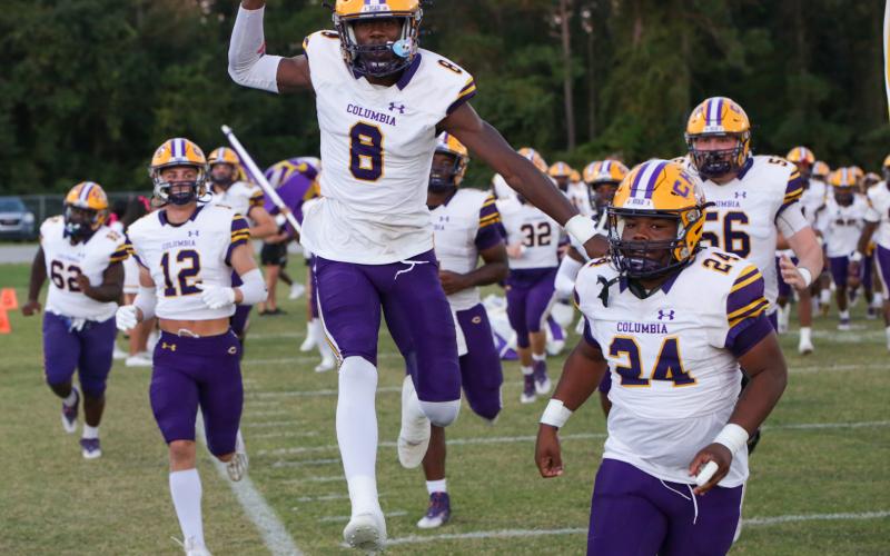 Columbia receiver Jaylen Cooper (8) leaps into the air alongside linebacker Wilson Philemon (24) as they lead their team onto the field prior to last Friday’s game against Orange Park. (BRENT KUYKENDALL/Lake City Reporter)