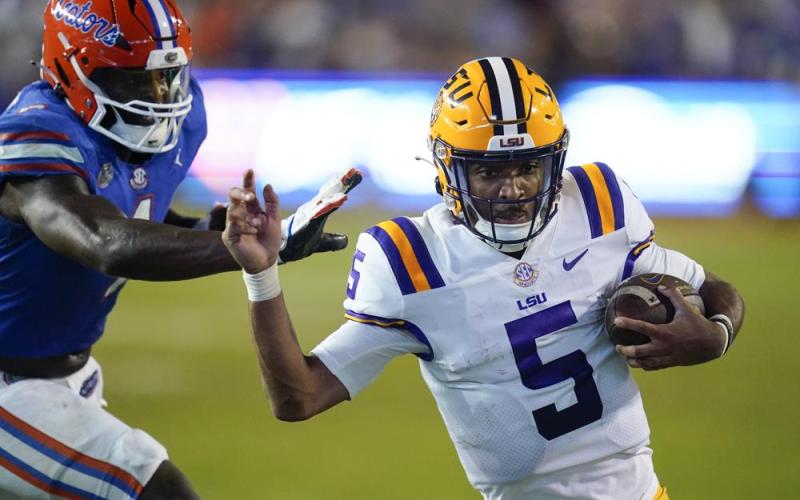 LSU quarterback Jayden Daniels slips by Florida linebacker Brenton Cox Jr. for a 9-yard touchdown run on Oct. 15 in Gainesville. (JOHN RAOUX/Associated Press)