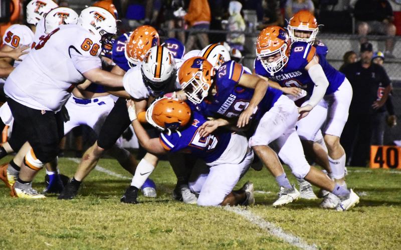 A host of Branford defenders, including Cole Certain (75), Ely Taylor (29) and Trevor Maddox (8) bring down a Trenton ballcarrier Friday. (ROB WOLFE/Special to the Reporter)