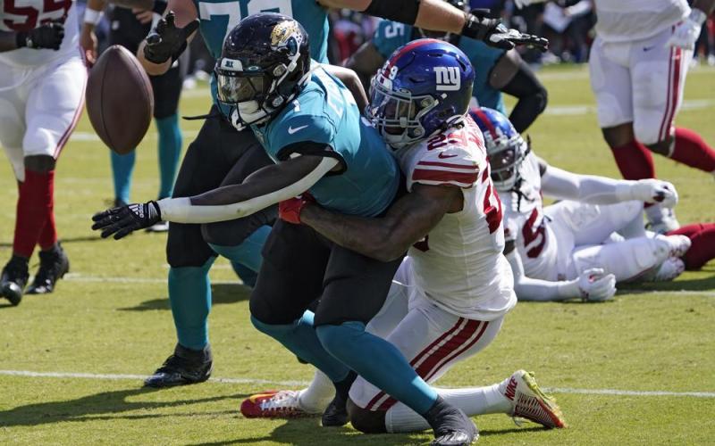 Jacksonville Jaguars running back Travis Etienne fumbles when he gets hit by New York Giants safety Xavier McKinney during Sunday's game in Jacksonville. (JOHN RAOUX/Associated Press)