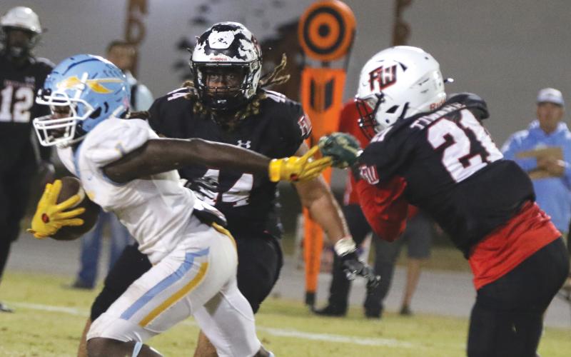 Chiefland running back Dakota Fisher (left) evades a tackle from Fort White’s Kamarion Griffin (44) and Darren Yates (44) on Friday. (MORGAN MCMULLEN/Lake City Reporter)