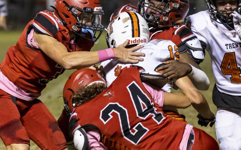 Lafayette linebacker Jalen Hill (5), safety Baylor Johnson (3) and linebacker Diego Garcia (24) tackle Trenton’s Brant Bivens on Friday night. (JACK HOWDESHELL/Special to the Reporter)