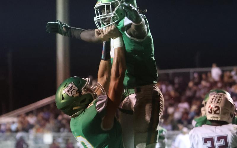 Suwannee receiver Kodi Lang (left) raises up running back Marquavious Owens as the two celebrate following Owens’ touchdown against Madison County on Oct. 14. (PAUL BUCHANAN/Special to the Reporter)