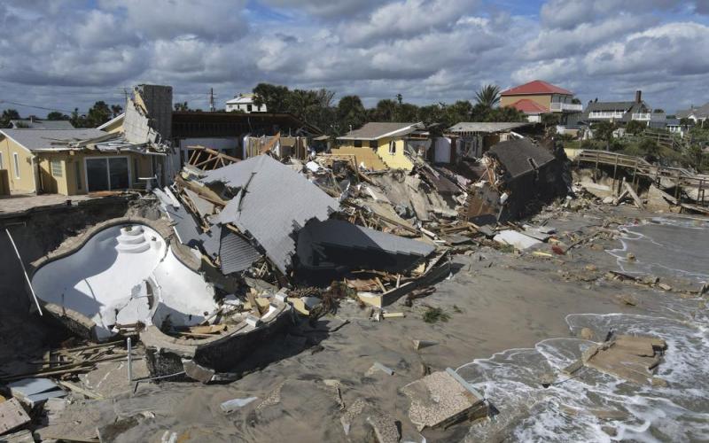 Homes are damaged and collapsed after the shore on which they stood was swept away following the passage of Hurricane Nicole Thursday in Wilbur-By-The-Sea. (REBECCA BLACKWELL/Associated Press)