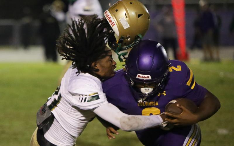 Columbia running back Tony Fulton plows through a Lincoln defender during Friday’s Region 1-3S quarterfinal at Tiger Stadium. (BRENT KUYKENDALL/Lake City Reporter)