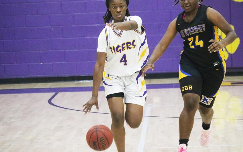 Columbia guard Eriel Baker calls out a play as she dribbles up the court defended by Newberry forward Desia Bryant on Thursday night. (JORDAN KROEGER/Lake City Reporter)