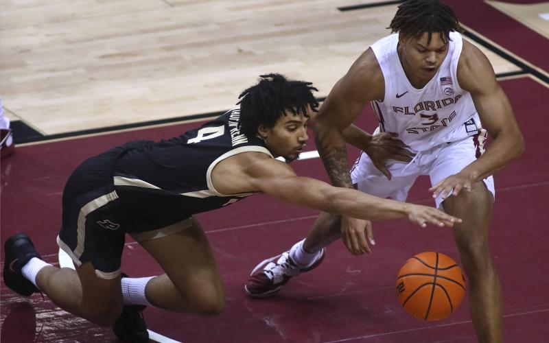 Purdue forward Trey Kaufman-Renn (4) and Florida State forward Cameron Corhen reach for the ball during Wednesday's game in Tallahassee. (PHIL SEARS/Associated Press)